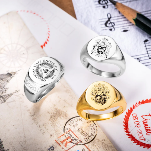 Personalized family crest signet rings displayed with heraldic artwork and engraving designs