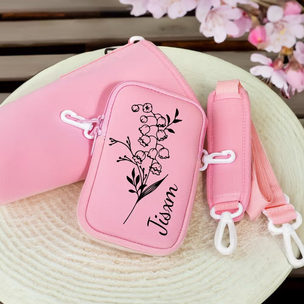 Close-up of pink birth flower tumbler carrier with custom name, phone pouch and strap