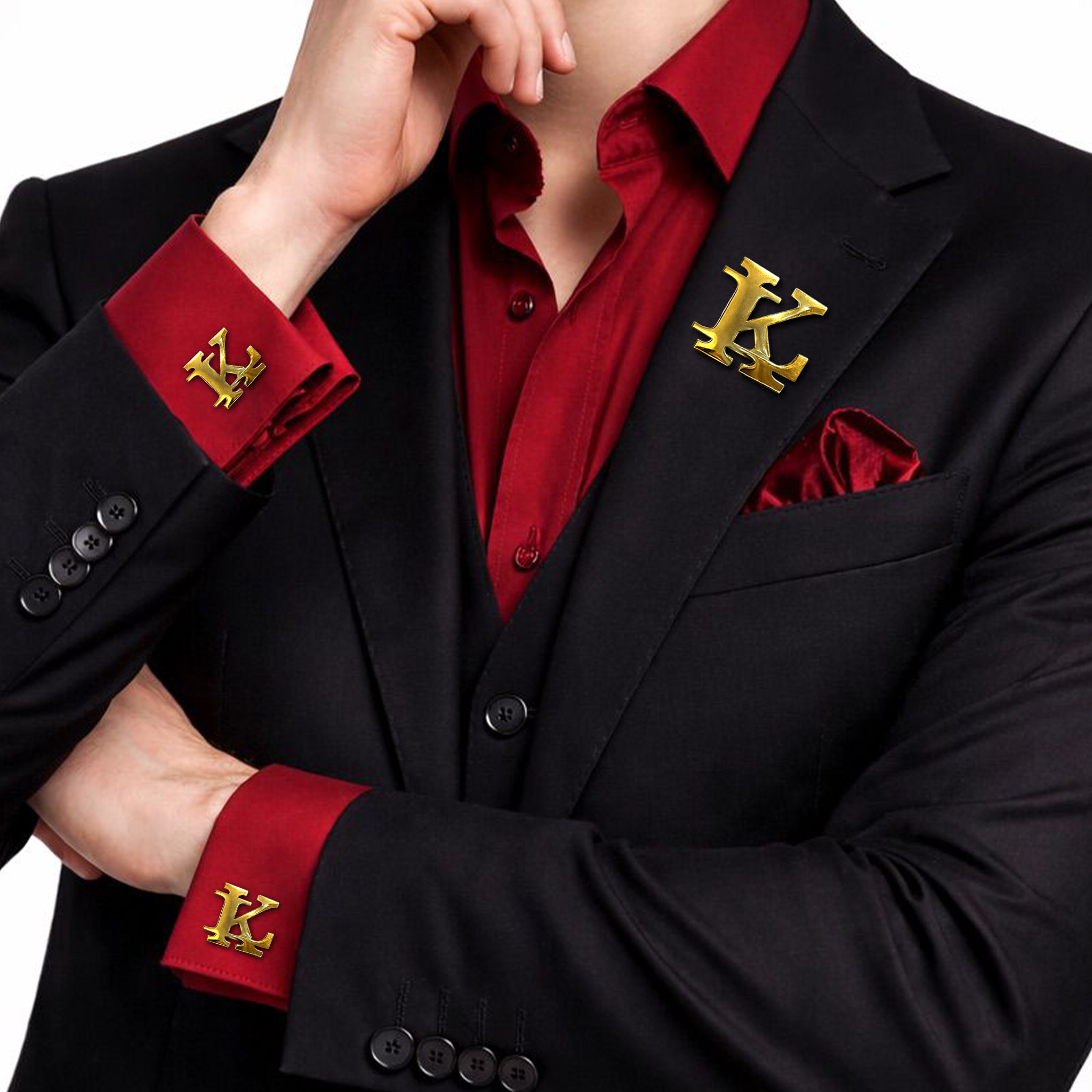 Gold interlocking initials cufflinks and lapel pin set worn with a black suit and red shirt