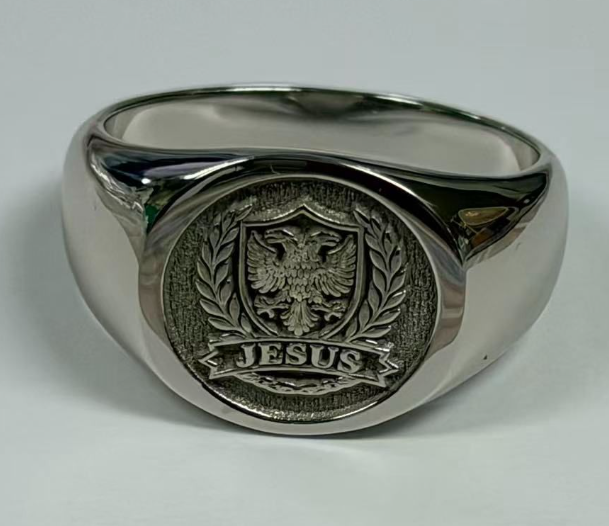 Silver-tone family crest signet ring featuring an engraved heraldic shield and polished band.
