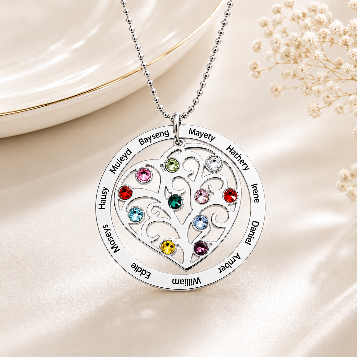 Silver heart family tree necklace with names and birthstones on a light background