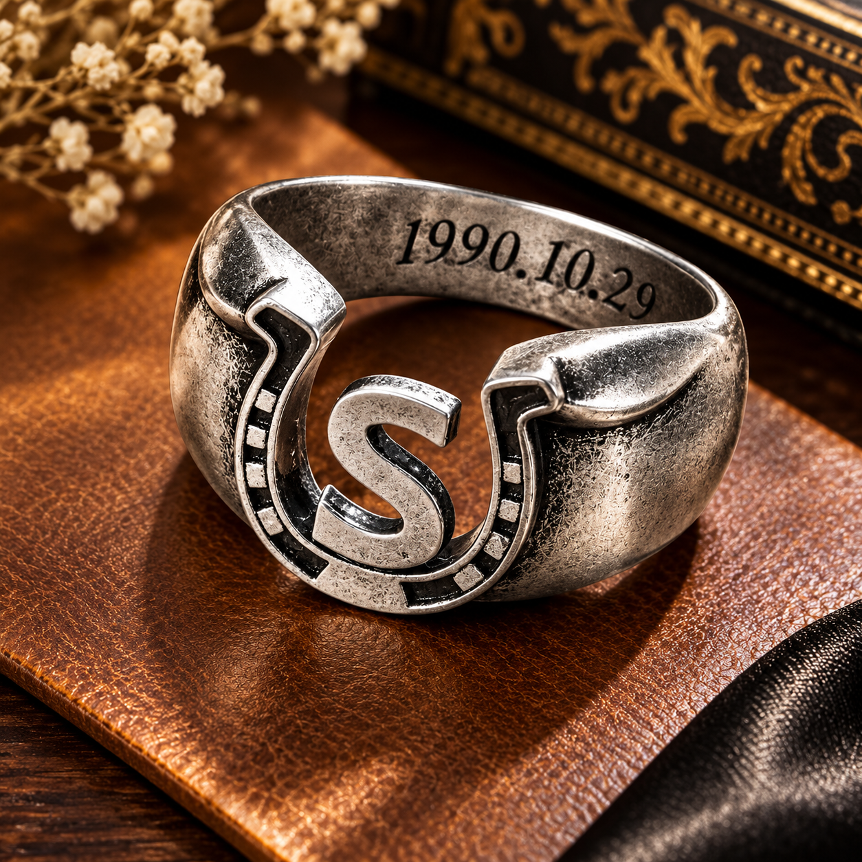 Personalized horseshoe ring with custom S initial and engraved date on vintage leather