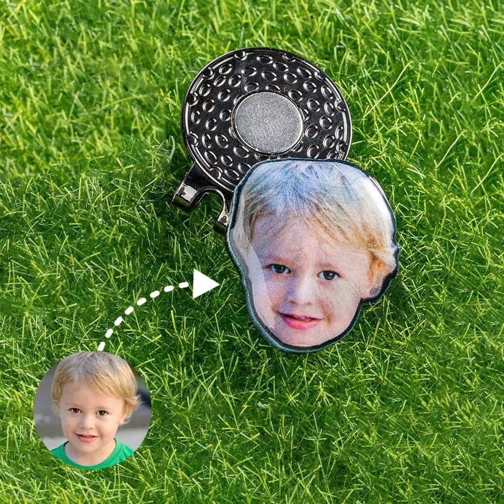 Custom child photo golf ball marker with magnetic hat clip displayed on grass