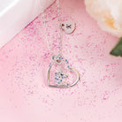 Silver unicorn heart pendant necklace with separate initial charm on pink background