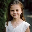 Girl wearing a personalized unicorn initial charm necklace