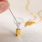 Filling personalized urn necklace with ashes using funnel