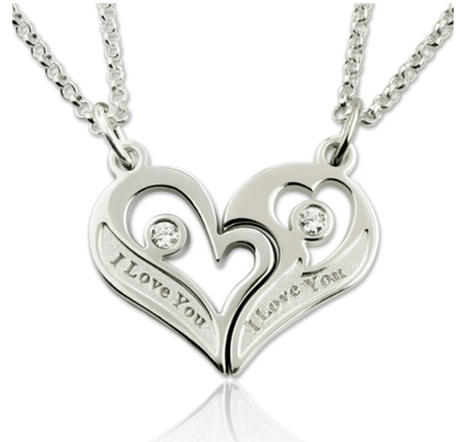 A pair of silver heart-shaped pendants, each with a gemstone and inscribed with "I Love You," connected to matching silver chains.