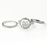 Three sterling silver rings with a central one featuring a monogram "TME" within a scalloped edge, surrounded by cubic zirconia, against a white background.