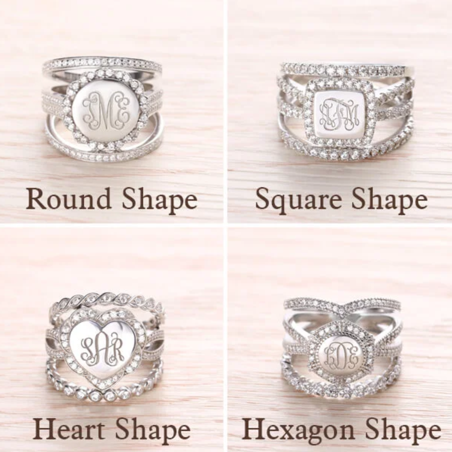 A collection of sterling silver rings with cubic zirconia, displayed in round, square, heart, and hexagon shapes, each featuring different monogram initials.