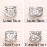 A collection of sterling silver rings with cubic zirconia, displayed in round, square, heart, and hexagon shapes, each featuring different monogram initials.