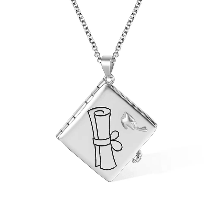 A silver necklace featuring a square locket with a graduation cap and diploma design on the front.