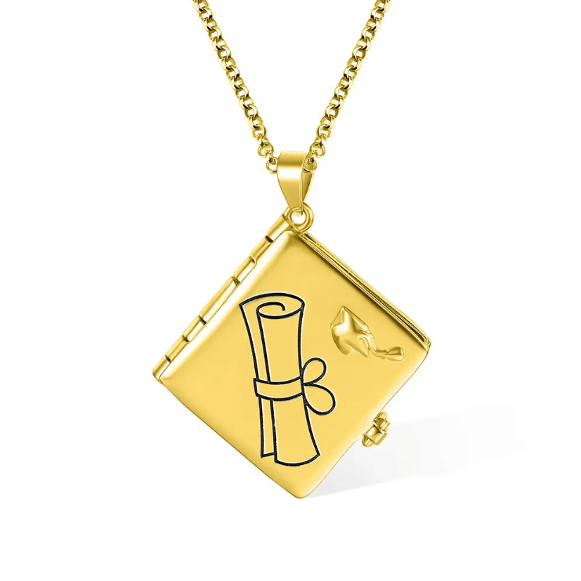 A gold necklace featuring a square locket with a graduation cap and diploma design on the front.