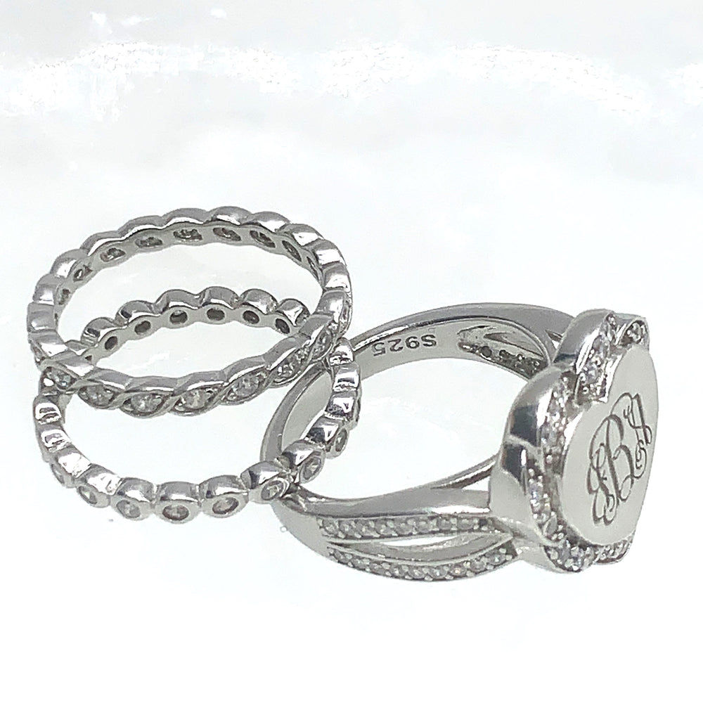 A set of three 925 sterling silver stackable rings, featuring a polished finish with one ring engraved with intricate initials "JBA" surrounded by sparkling cubic zirconia.