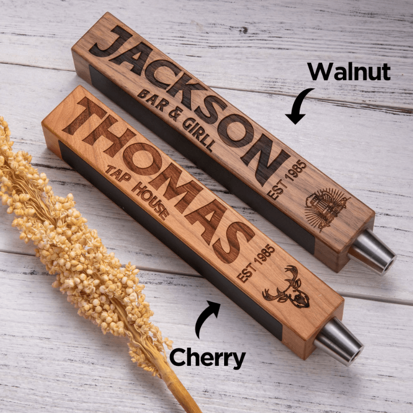 Two custom beer tap handles with personalized engraving and chalkboard decals, labeled "Jackson Bar & Grill" in walnut and "Thomas Tap House" in cherry wood.