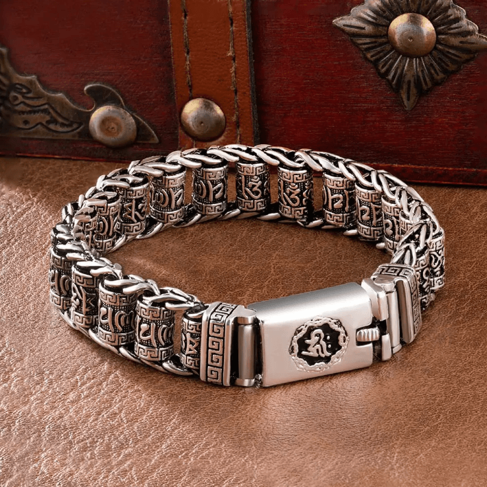 Ornate silver bracelet featuring intricate geometric patterns and a secure clasp, displayed on a vintage leather backdrop.