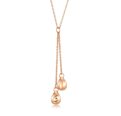 Rose gold Y-shaped necklace with two teardrop pendants, one engraved with initial 'S', on a simple chain.