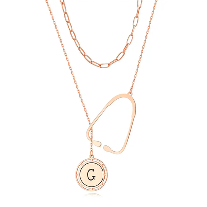 Layered rose gold necklace with a stethoscope pendant and a custom initial charm, displayed against a white background.
