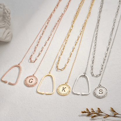 Set of layered necklaces with stethoscope pendants and custom initial charms in rose gold, gold, and silver, displayed on a white background.