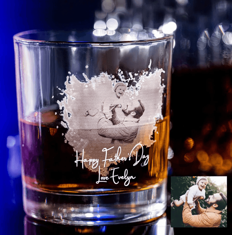 Custom engraved whiskey glass with a family photo of a father lifting his child and the message "Happy Father's Day, Love Evelyn" etched below.