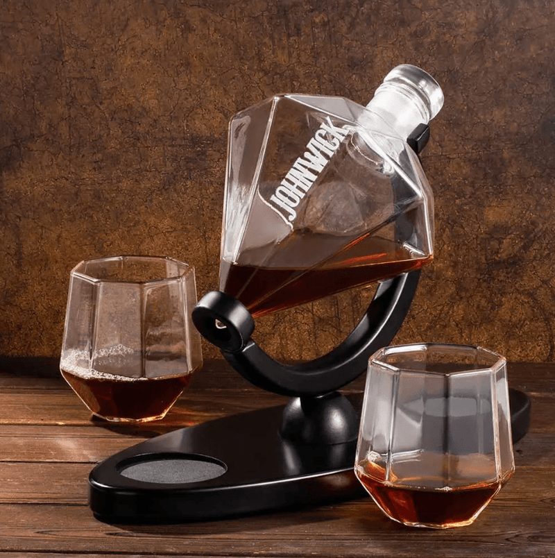 Custom engraved diamond-shaped whiskey decanter set with two glasses on a wooden table, ideal for gifting.