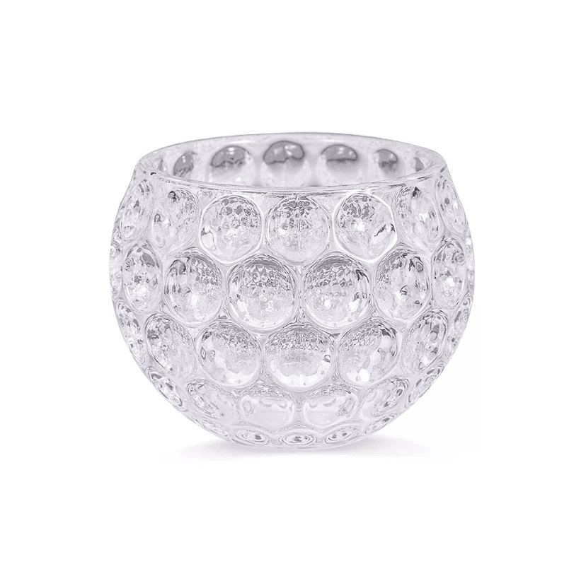 Close-up of an empty golf ball-shaped whiskey glass with a dimpled pattern, made from clear crystal, against a white background.