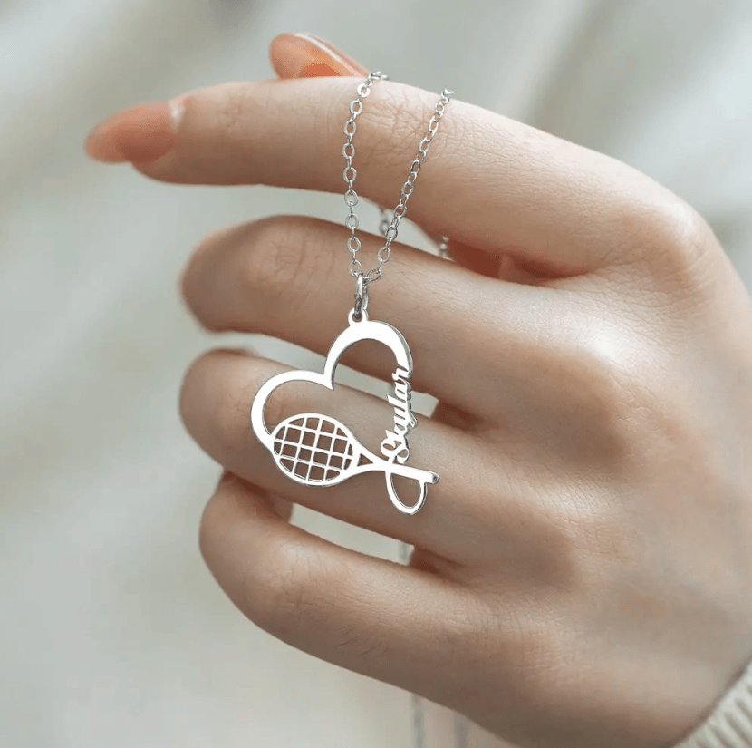Personalized silver tennis racket necklace with a heart charm, customized with the name "Skylar." Perfect sports jewelry gift for tennis lovers and athletes.