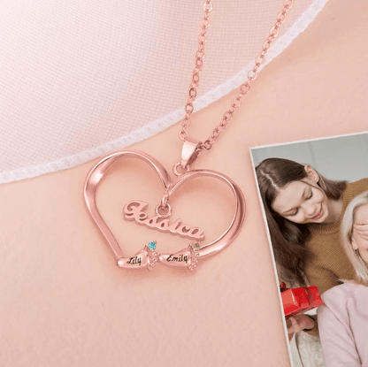 A rose gold heart-shaped necklace with "Jessica" inscribed, featuring two names, Lily and Emily, adorned with colorful gemstones. A touching photo of a young woman and an elderly woman is in the background.