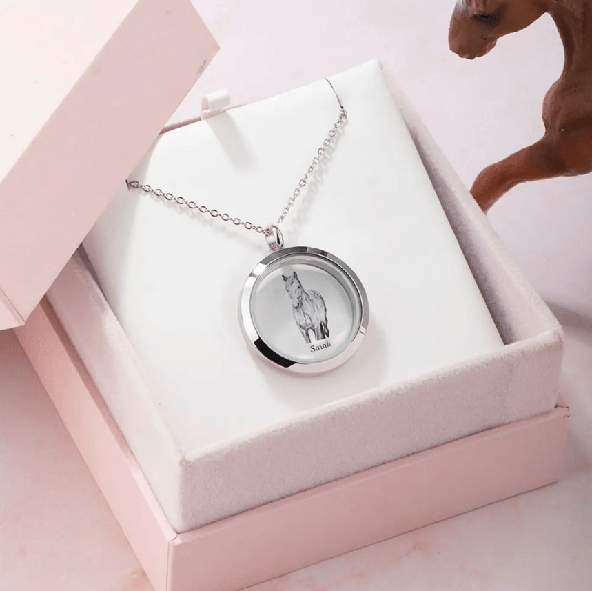 Silver locket with horse image named 'Sarah' in a white gift box next to a horse figurine