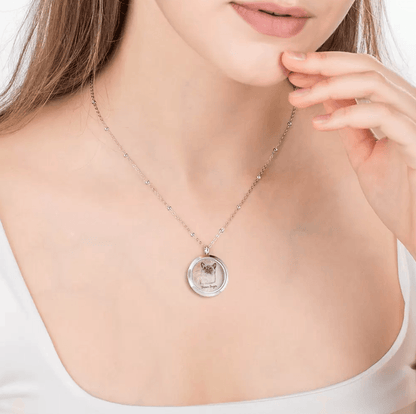 Woman wearing a silver necklace with a locket featuring the image of a cat named 'Brown Sugar