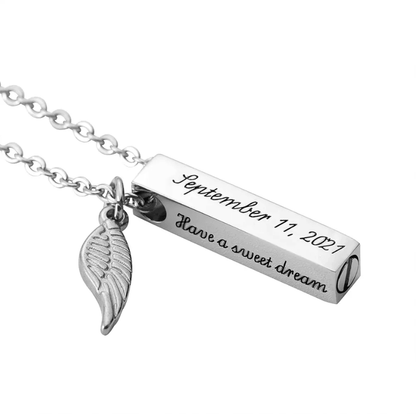 Silver bar urn necklace with engraved date and message, accompanied by a delicate feather charm, on a chain link