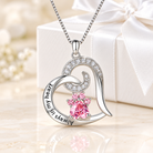 Elegant silver heart pendant necklace featuring sparkling pink paw print gemstones and “Always in my heart” engraving, displayed on a soft white beige background with a white gift box and satin ribbon.