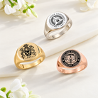 Three custom engraved signet rings in silver, gold and rose gold tones featuring family and university crests