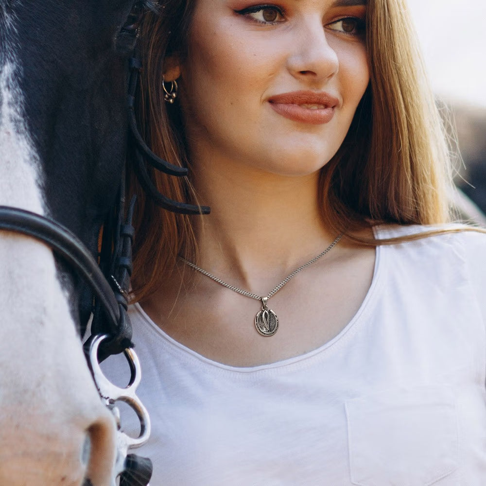Silver horse hoof pendant necklace worn by woman