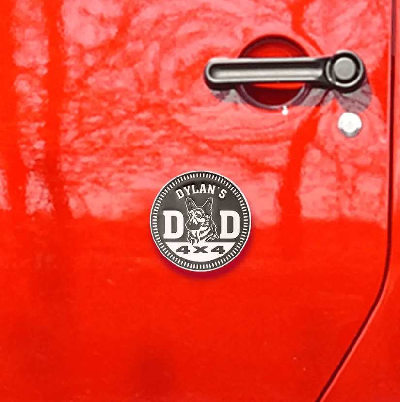 Custom 'Dylan's Dad 4x4' badge on a red car door, featuring a German Shepherd avatar, symbolizing pet pride.