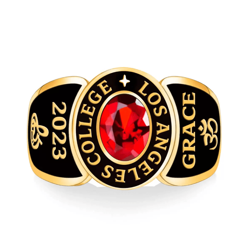 A gold college ring with a red gemstone, inscribed with "COLLEGE LOS ANGELES," "2023," and "GRACE" with an Om symbol on the sides.