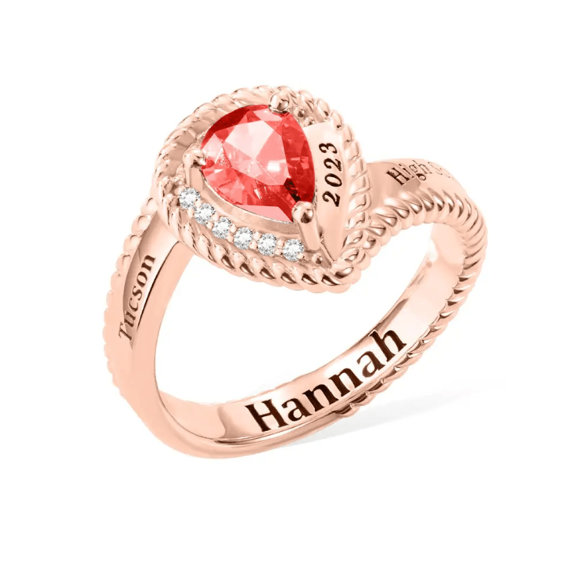 Rose gold class ring with red heart-shaped gem, '2023, High, Hannah' engraving for personalized graduation.