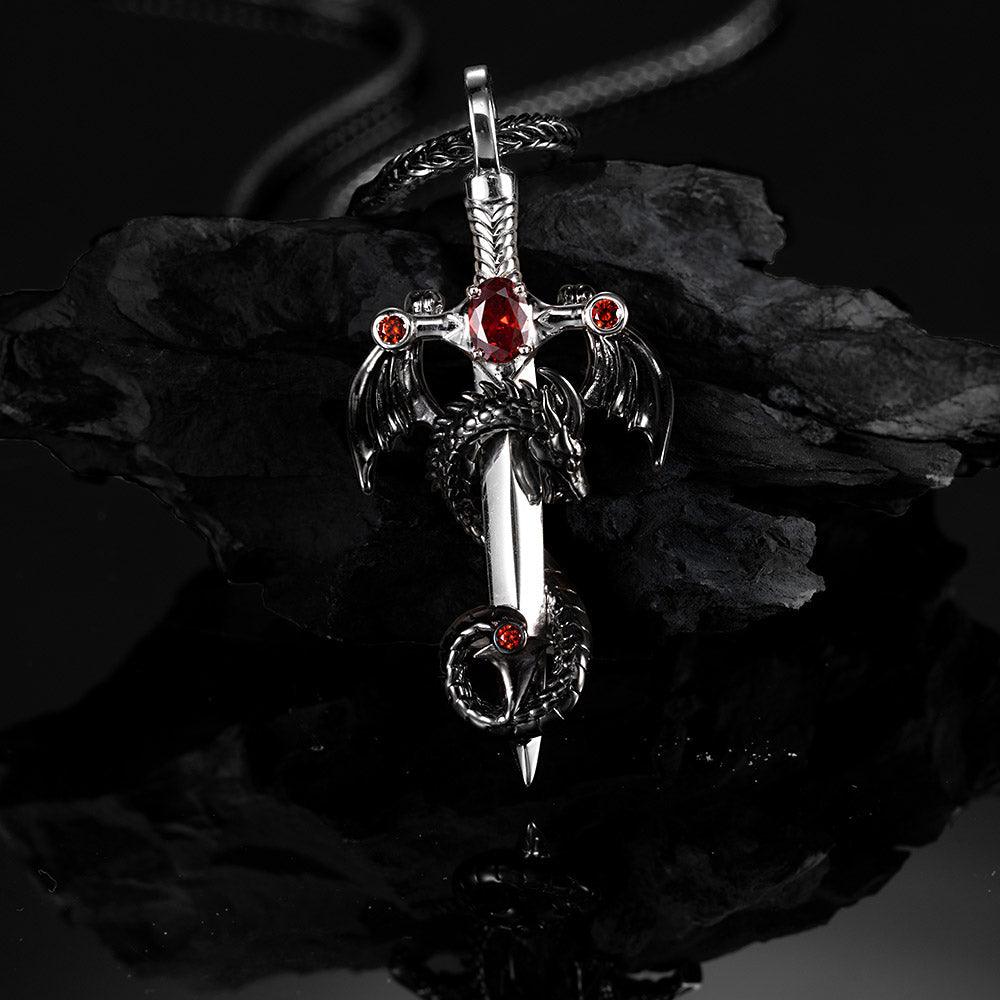 A pendant featuring a black dragon with red gemstones wrapped around a silver sword, displayed on a foxtail chain against a dark background.