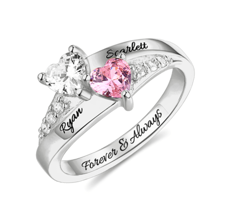 A silver ring with two heart-shaped gemstones, one clear and one pink, personalized with the names Ryan and Scarlett, and the inscription "Forever & Always."