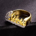 Gold and silver 'Olivia' name ring with intricate script design, displayed on a textured black surface.