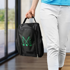 Black personalized golf shoe bag with green embroidered golf design being carried