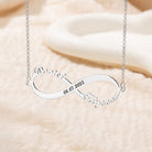 Personalized silver two name infinity necklace displayed on cream fabric