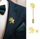 Gold custom initial lapel pins in "BA" letters displayed on a navy suit, highlighting a personalized and sophisticated touch for formal attire.