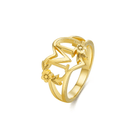 Gold initial 'M' ring with heart and flower design on a white background.