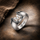 Personalized M initial horseshoe ring with LUCKY engraving on rustic dark background