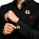 Silver interlocking initials cufflinks and matching lapel pin set worn with a black suit