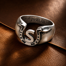 Engraved S initial horseshoe ring with custom date on warm brown leather