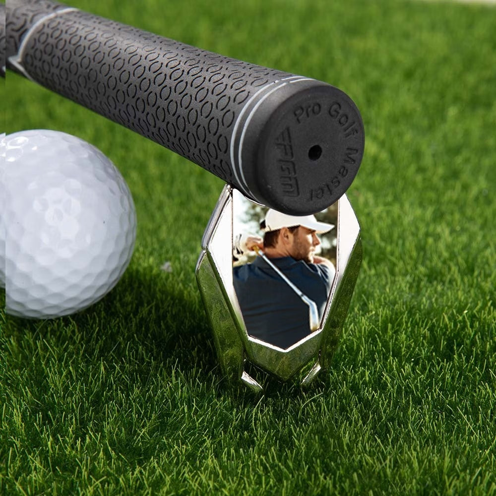 Custom photo golf divot repair tool beside golf ball and golf club grip