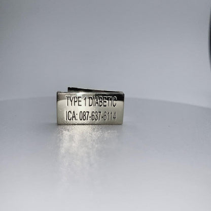 A gold medical tag with the inscription "TYPE 1 DIABETIC ICA: 087-637-6114" displayed on a white background.