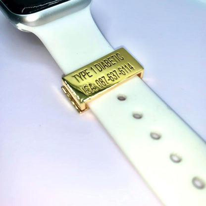 A gold medical tag on a white smartwatch band with the inscription "TYPE 1 DIABETIC ICA: 087-637-6114" displayed on a white background.