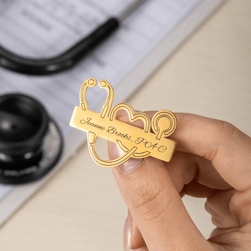 Person holding a Personalized Medical School Graduation Lapel Pin with a custom stethoscope design and engraved name, showcasing high-quality craftsmanship.